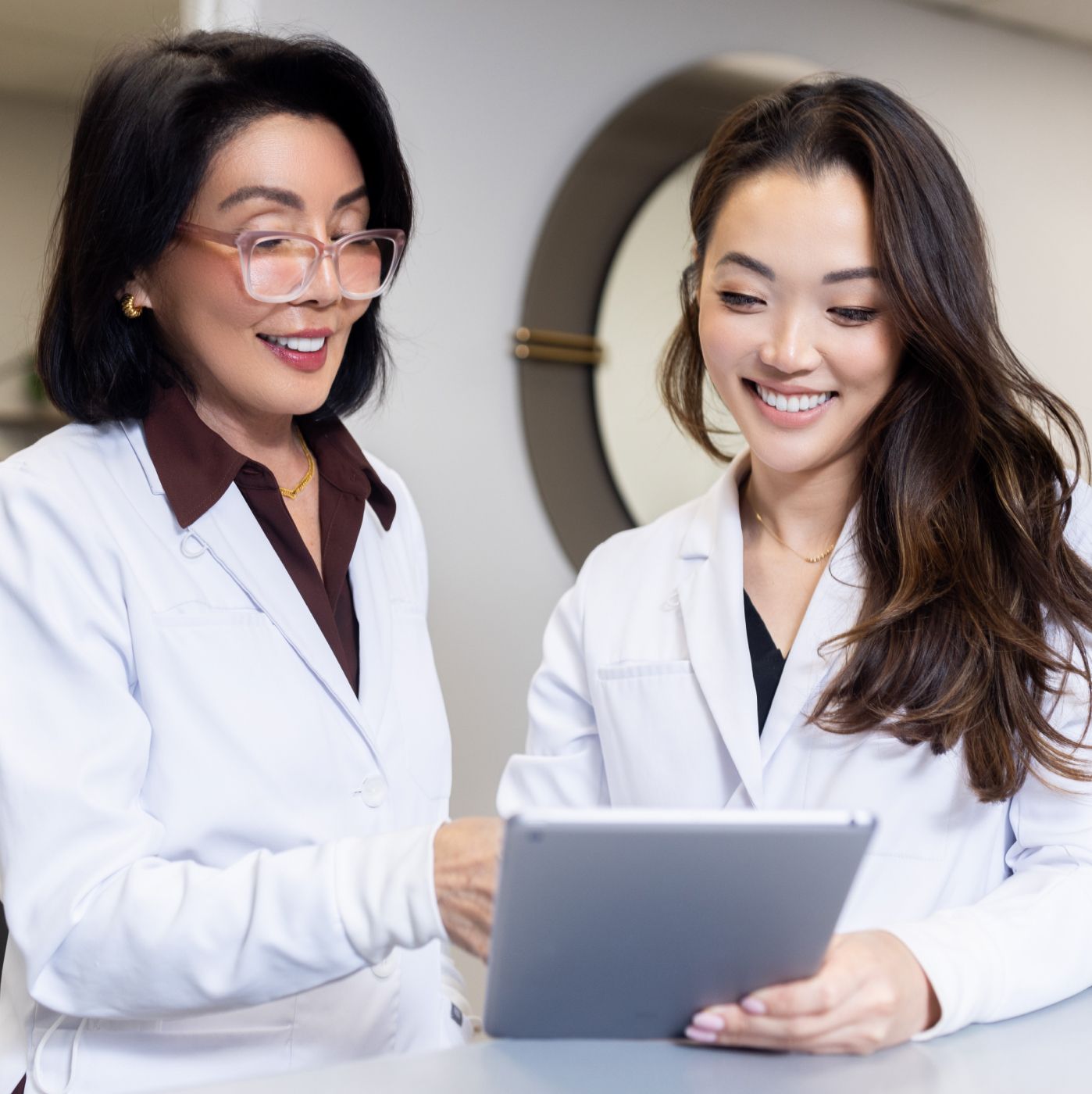 Two professionals discussing tablet in clinic