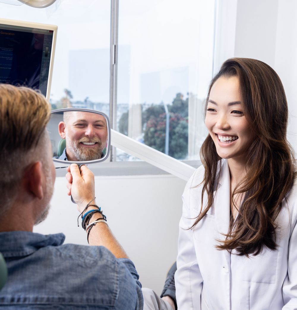 Patient and dentist smiling during a consultation.